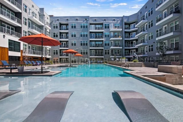 Apartment buildings surround blue swimming pool with lounge chairs exterior at RYE SoBo in Denver Student Accommodation