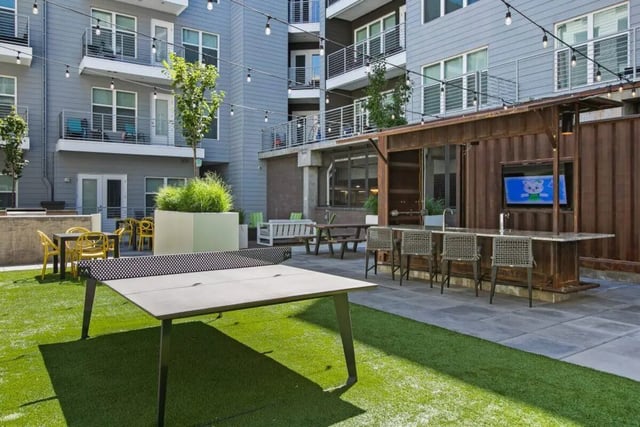 Ping pong table bar with chairs and TV exterior at RYE SoBo in Denver Student Accommodation