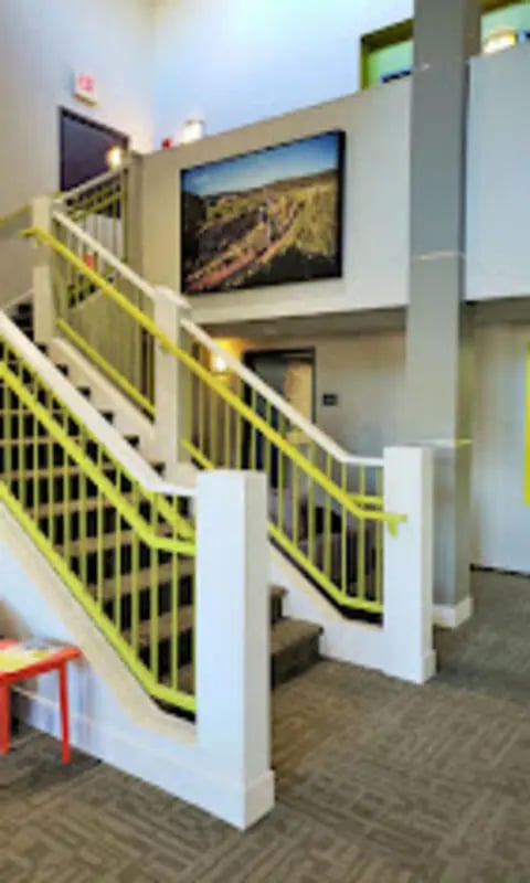 Stairs with yellow railings and art Interior at The House Apartments in Eagle Student Accommodation