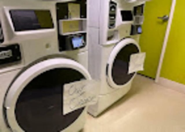 Washing machines with signs laundry room exterior at The House Apartments in Eagle Student Accommodation
