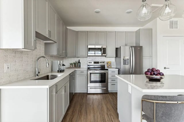 Modern kitchen with stainless steel appliances kitchen island kitchen at Vida @ Fitzsimons in Aurora Student Accommodation