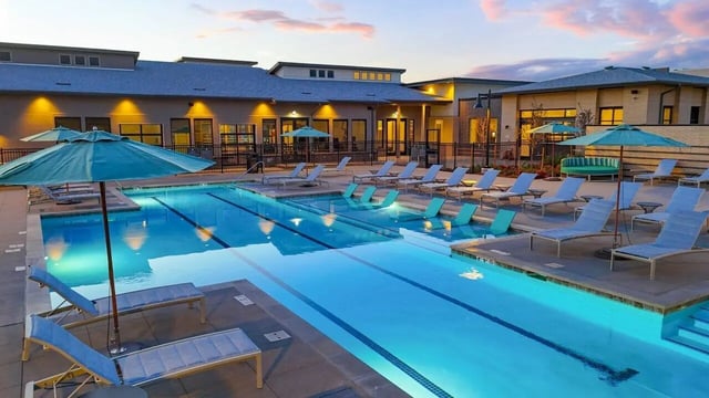 Pool lounge chairs umbrellas and swimming pool exterior at Vida @ Fitzsimons in Aurora Student Accommodation