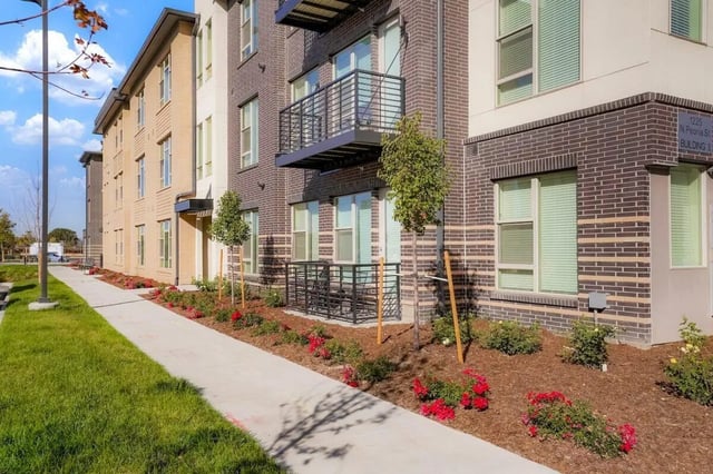 Brick building with balconies and landscaping exterior at Vida @ Fitzsimons in Aurora Student Accommodation