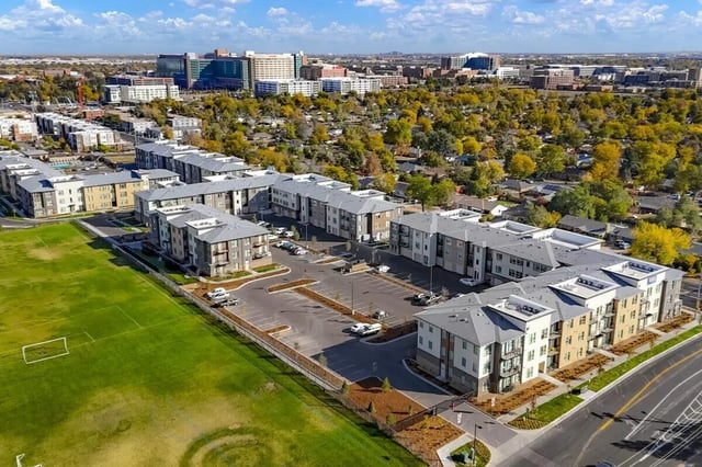 Apartment buildings parking lot green field exterior at Vida @ Fitzsimons in Aurora Student Accommodation