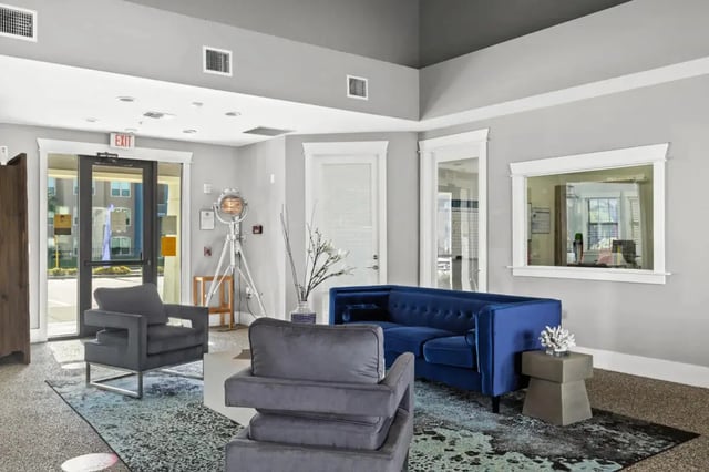 Blue sofa and grey chairs lounge area at Campus Quarters at Corpus Christi in Corpus Christi Student Accommodation