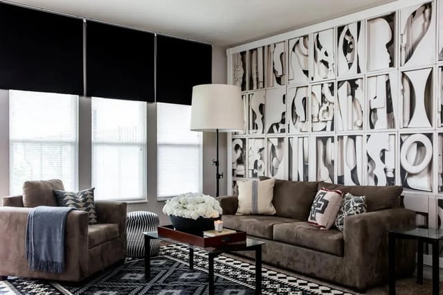 Sofa, armchair, and wall art living room at Campus Quarters at Corpus Christi in Corpus Christi Student Accommodation