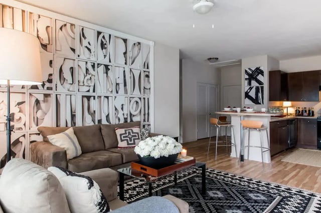 Sofa kitchen island stools and abstract art living room at Campus Quarters at Corpus Christi in Corpus Christi Student Accommodation