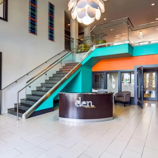 Reception desk stairs modern chandelier common area at The Den in Columbia Student Accommodation