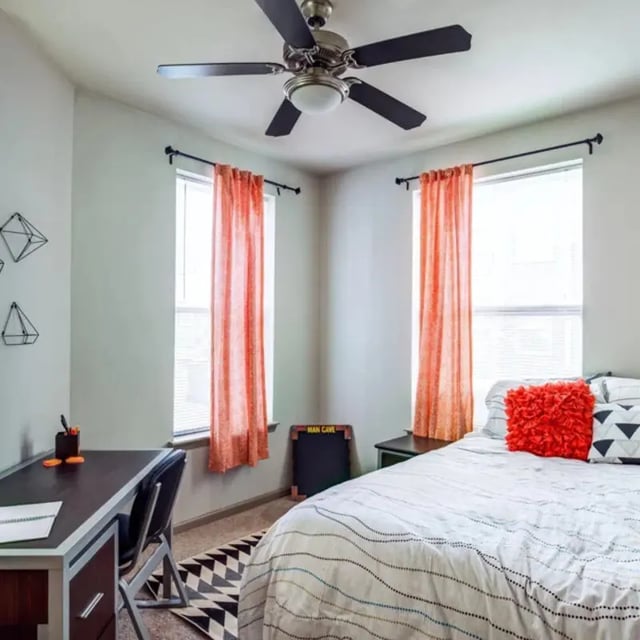 Desk bed orange curtains geometric decor bedroom at The Den in Columbia Student Accommodation