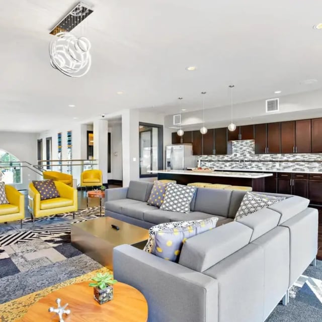 Modern living room with sectional couch and kitchen living room at The Den in Columbia Student Accommodation