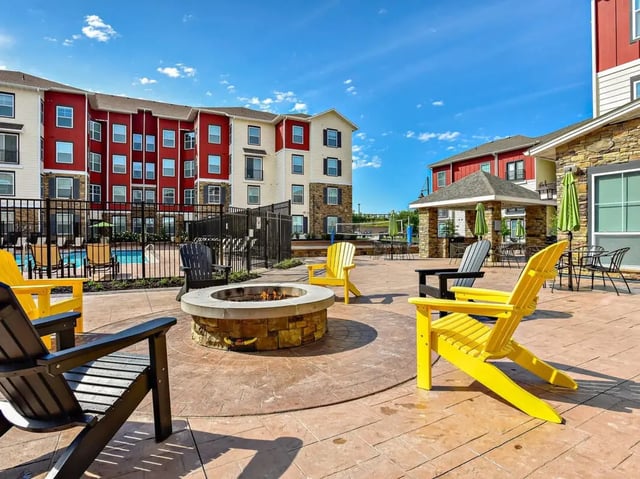 Fire pit and colorful chairs outdoor amenity area exterior at The Den in Columbia Student Accommodation
