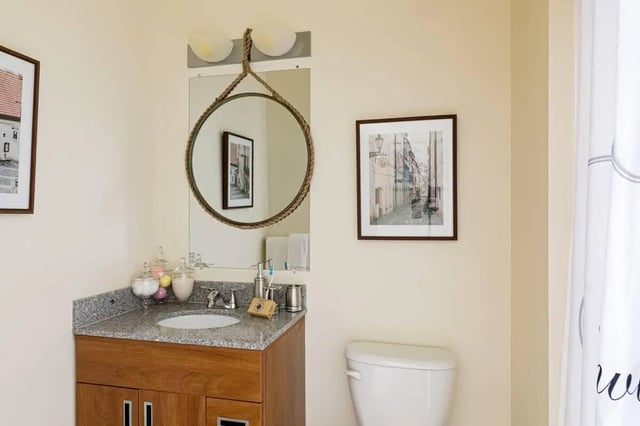 Wood vanity mirror with rope frame and artwork bathroom at 20 Hawley Street in Binghamton Student Accommodation