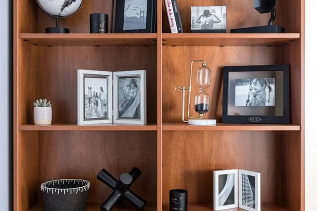 Shelf with framed photos and hourglass decor bookshelf at 20 Hawley Street in Binghamton Student Accommodation