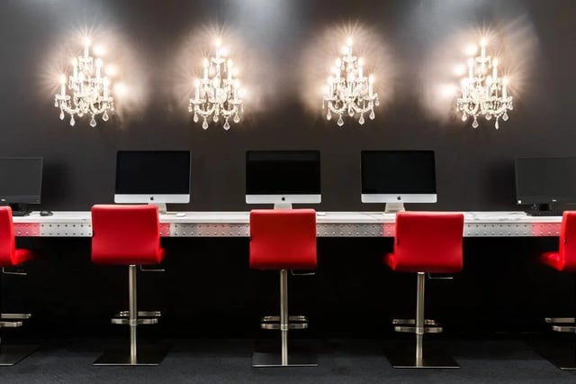 Computers and red chairs under chandeliers study area at 20 Hawley Street in Binghamton Student Accommodation