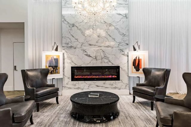 Four leather chairs around marble fireplace living room at 20 Hawley Street in Binghamton Student Accommodation