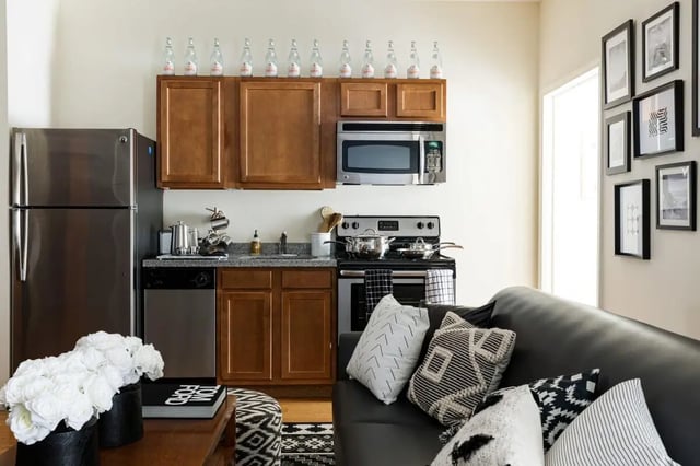 Refrigerator stove cabinets couch living room kitchen at 20 Hawley Street in Binghamton Student Accommodation