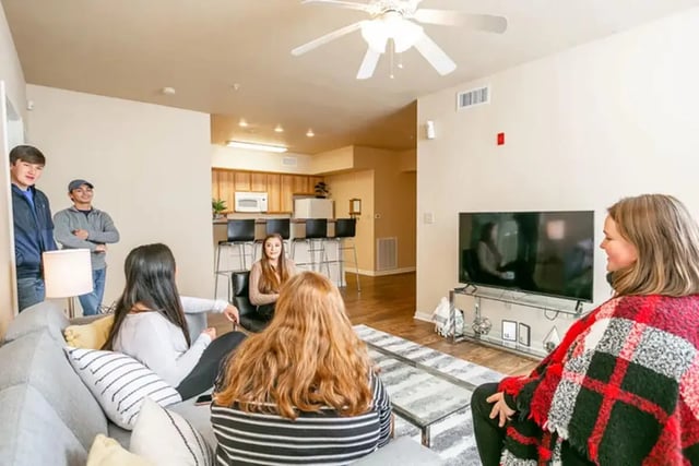 Friends in apartment living room with kitchen living room at University Crossing Apartments Ruston in Ruston Student Accommodation