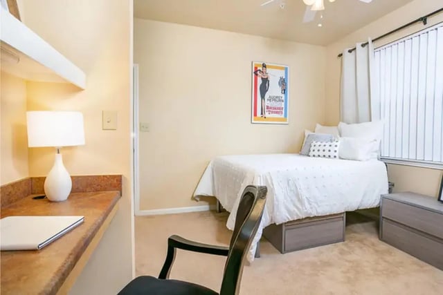 Desk lamp bed dresser with Audrey Hepburn poster Bedroom at University Crossing Apartments Ruston in Ruston Student Accommodation