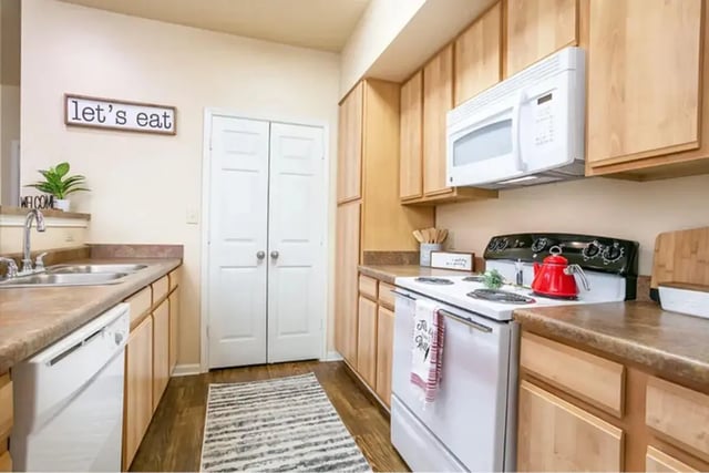 Kitchen with cabinets stove sink and microwave kitchen at University Crossing Apartments Ruston in Ruston Student Accommodation