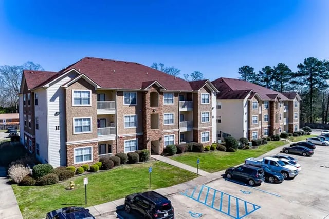 Apartment buildings with balconies and parking lot exterior at University Crossing Apartments Ruston in Ruston Student Accommodation