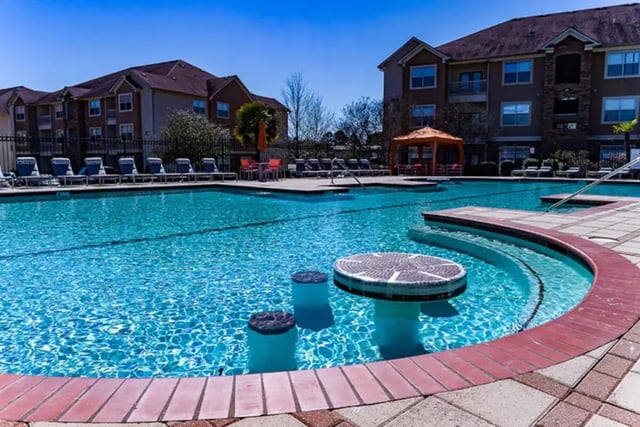 Pool with swim up bar and lounge chairs exterior at University Crossing Apartments Ruston in Ruston Student Accommodation