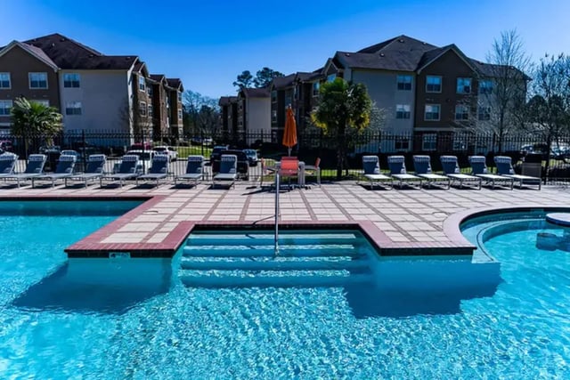 Deck chairs beside swimming pool exterior living room at University Crossing Apartments Ruston in Ruston Student Accommodation