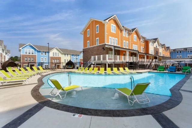 Pool lounge chairs and modern apartment buildings exterior at The Dillon Bloomington in Bloomington Student Accommodation