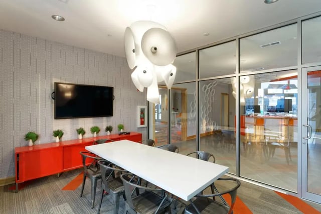 White table chairs TV fire extinguisher communal area at The Dillon Bloomington in Bloomington Student Accommodation