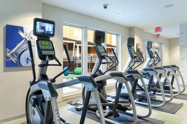 Elliptical machines with screens and art gym area at The Dillon Bloomington in Bloomington Student Accommodation
