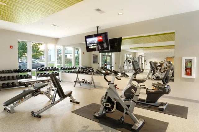 Dumbbells weight benches exercise bikes gym fitness room at The Dillon Bloomington in Bloomington Student Accommodation