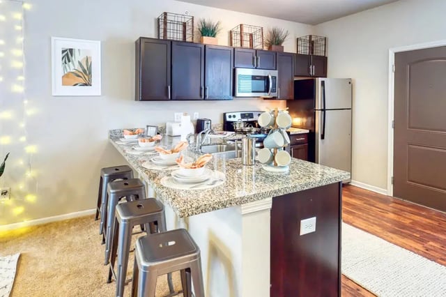 Island bar with stools refrigerator microwave cabinets kitchen at The Dillon Bloomington in Bloomington Student Accommodation