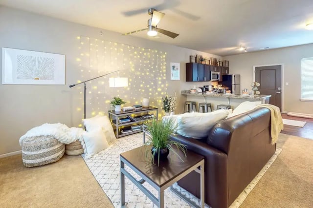 Brown leather sofa fairy lights kitchen living room at The Dillon Bloomington in Bloomington Student Accommodation