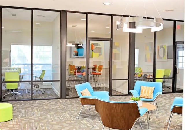 Blue chairs glass walls meeting rooms lobby at The Overlook at Nacogdoches in Nacogdoches Student Accommodation