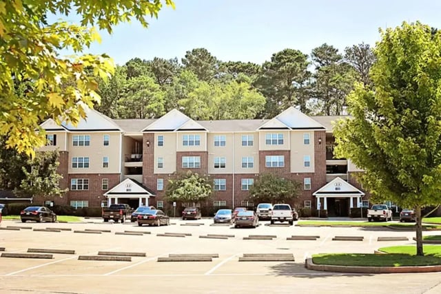Apartment building with parking lot and cars exterior at The Overlook at Nacogdoches in Nacogdoches Student Accommodation