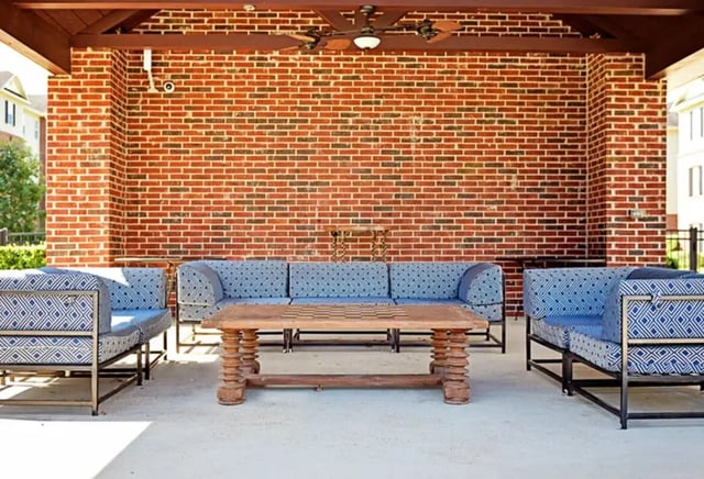 Blue patterned sofas and wooden table living room at The Overlook at Nacogdoches in Nacogdoches Student Accommodation