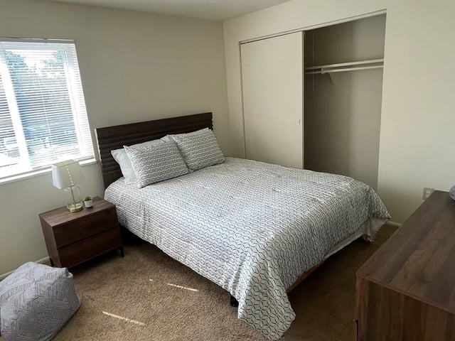 Bed with patterned duvet closet nightstand bedroom at Breckenridge Apartments in Nampa Student Accommodation