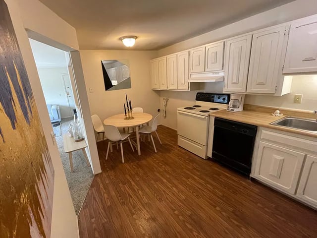 Dining table chairs oven dishwasher kitchen area at Breckenridge Apartments in Nampa Student Accommodation