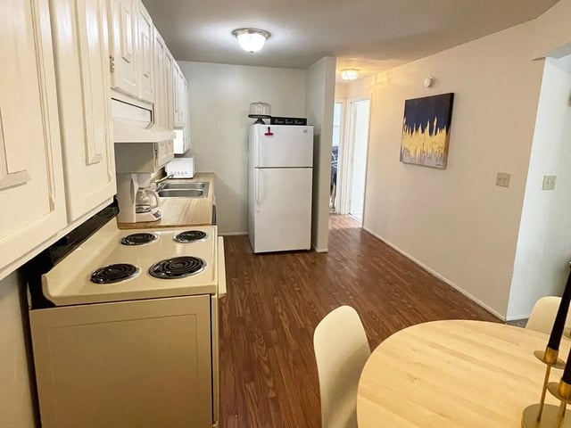 Stove refrigerator dining table kitchen at Breckenridge Apartments in Nampa Student Accommodation