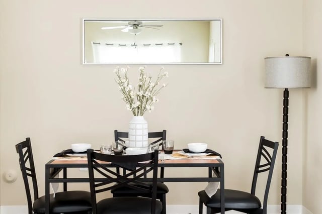 Dining table with chairs mirror and lamp dining area at University Village at Greensboro in Greensboro Student Accommodation