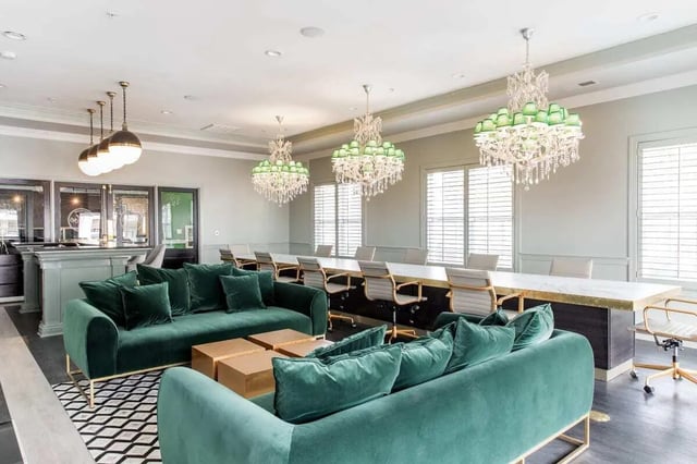 Green sofas bar long table chandeliers study area at University Village at Greensboro in Greensboro Student Accommodation