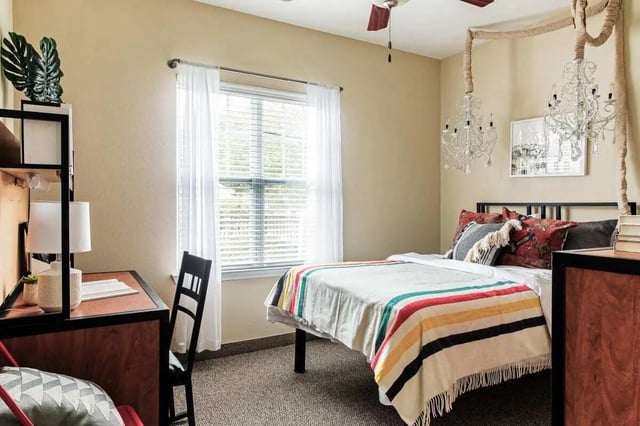 Desk bed with decorative chandeliers Bedroom at University Village at Greensboro in Greensboro Student Accommodation