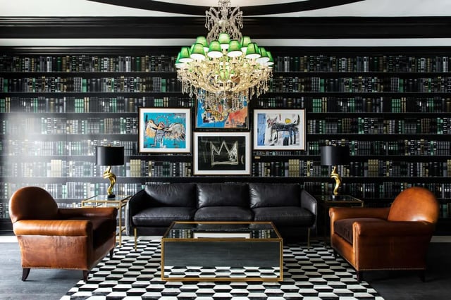 Leather sofa and chairs on checkered rug living room at University Village at Greensboro in Greensboro Student Accommodation