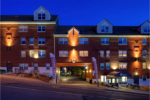 Brick building entrance with flags and entrance exterior at Auden Ithaca in Ithaca Student Accommodation
