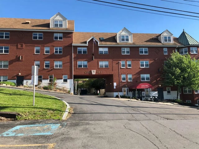 Brick building with many windows and green lawn exterior at Auden Ithaca in Ithaca Student Accommodation