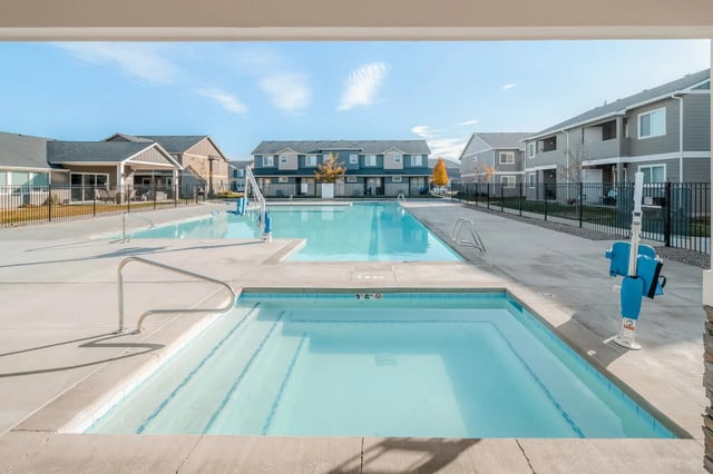 Swimming pools with apartment buildings exterior at Ridgecrest Commons in Nampa Student Accommodation