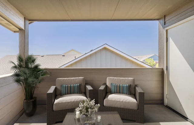 Two armchairs plant and table balcony exterior at Ridgecrest Commons in Nampa Student Accommodation