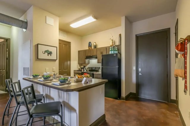 Kitchen island with bar stools and appliances kitchen at The Crimson in Tuscaloosa Student Accommodation