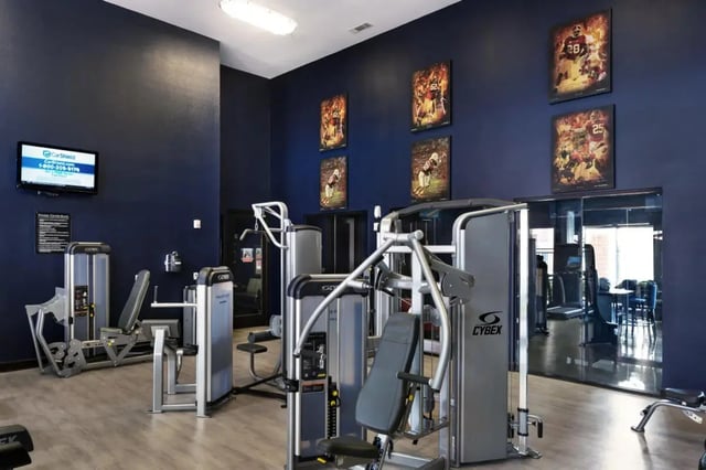 Weight machines and posters decorate gym Image Type at The Crimson in Tuscaloosa Student Accommodation