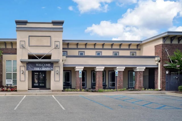 Building entrance with columns and "Welcome" banner exterior at The Crimson in Tuscaloosa Student Accommodation
