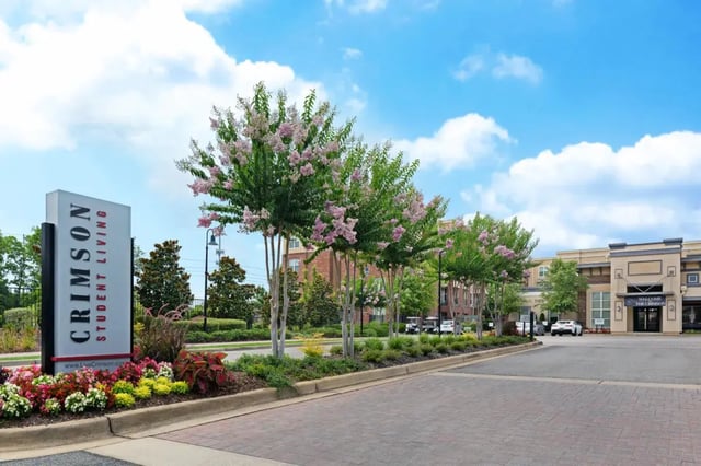 Crimson Student Living sign building and trees exterior at The Crimson in Tuscaloosa Student Accommodation